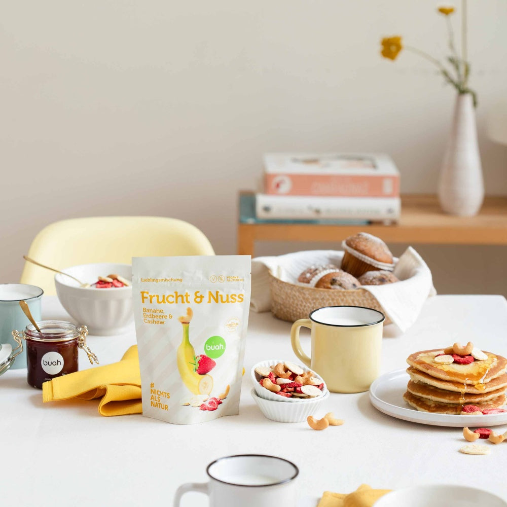 buah Frucht & Nuss Mischung steht auf einem Frühstückstisch neben einer Schale mit der Frucht & Nuss Mischung