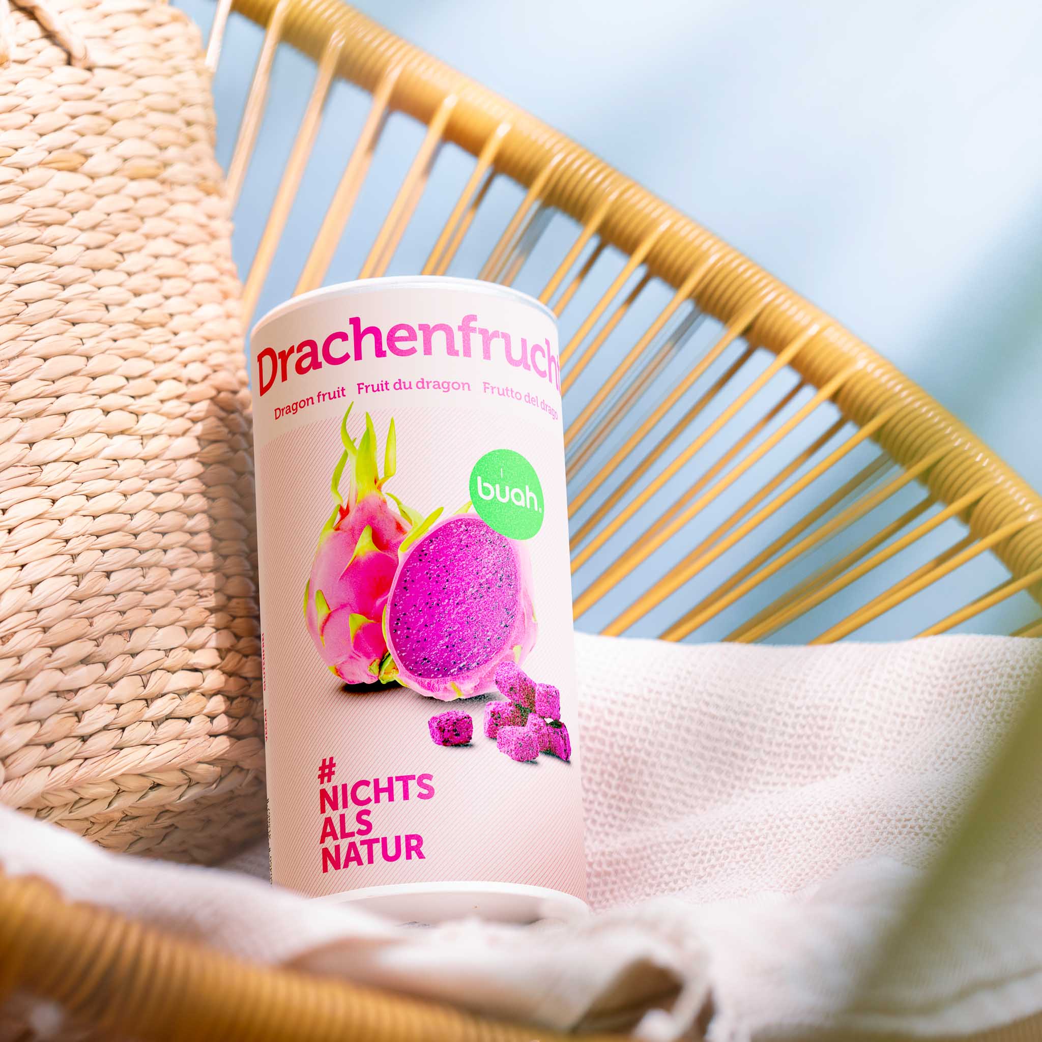buah Dose gefriergetrocknete Drachenfrucht neben einer Starndtasche auf einer Sonnenliege