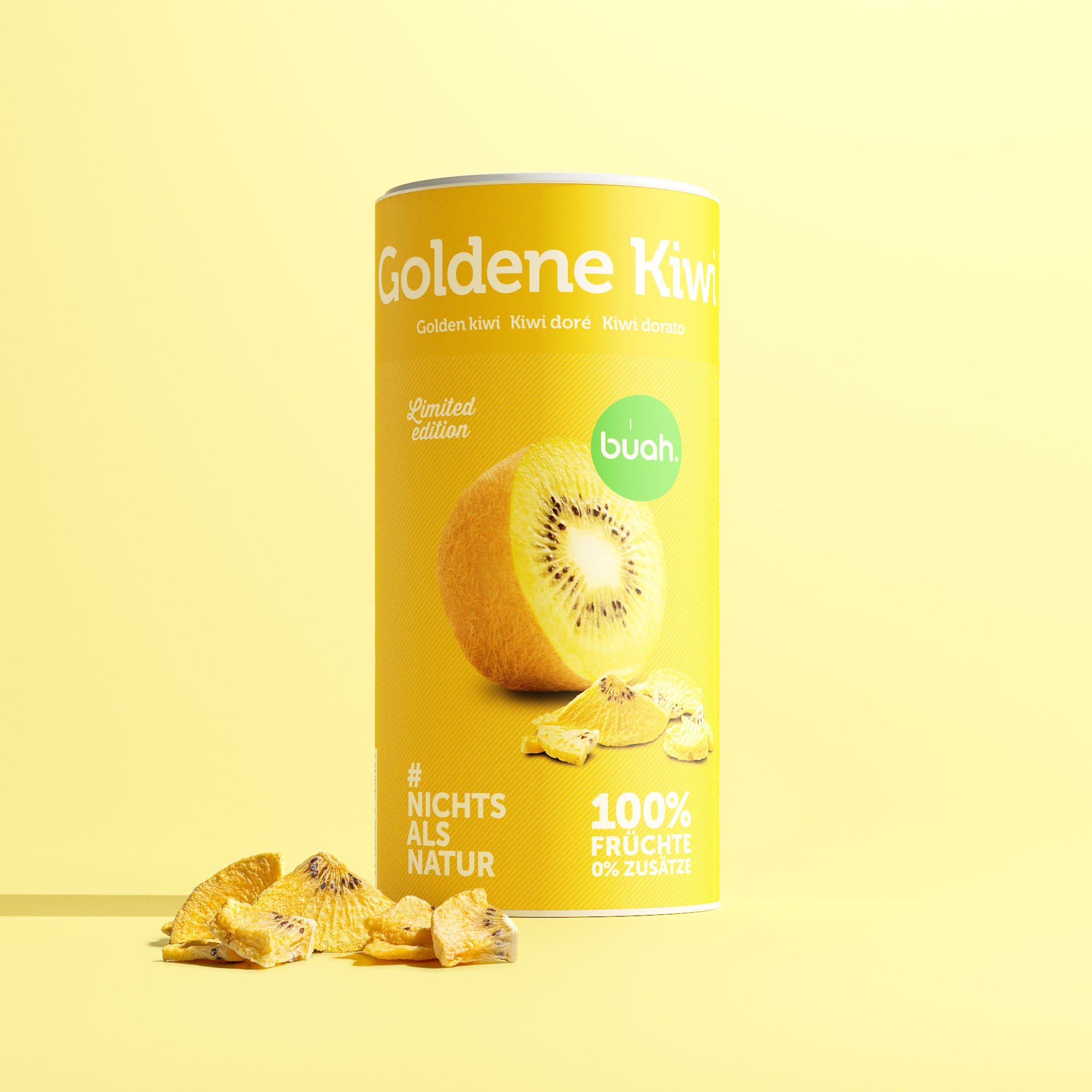 Eine gelbe Dose buah gefriergetrocknete Goldene Kiwi steht zusammen mit knusprigen Fruchtstücken im Zentrum vor einem hellgelben Hintergrund.
