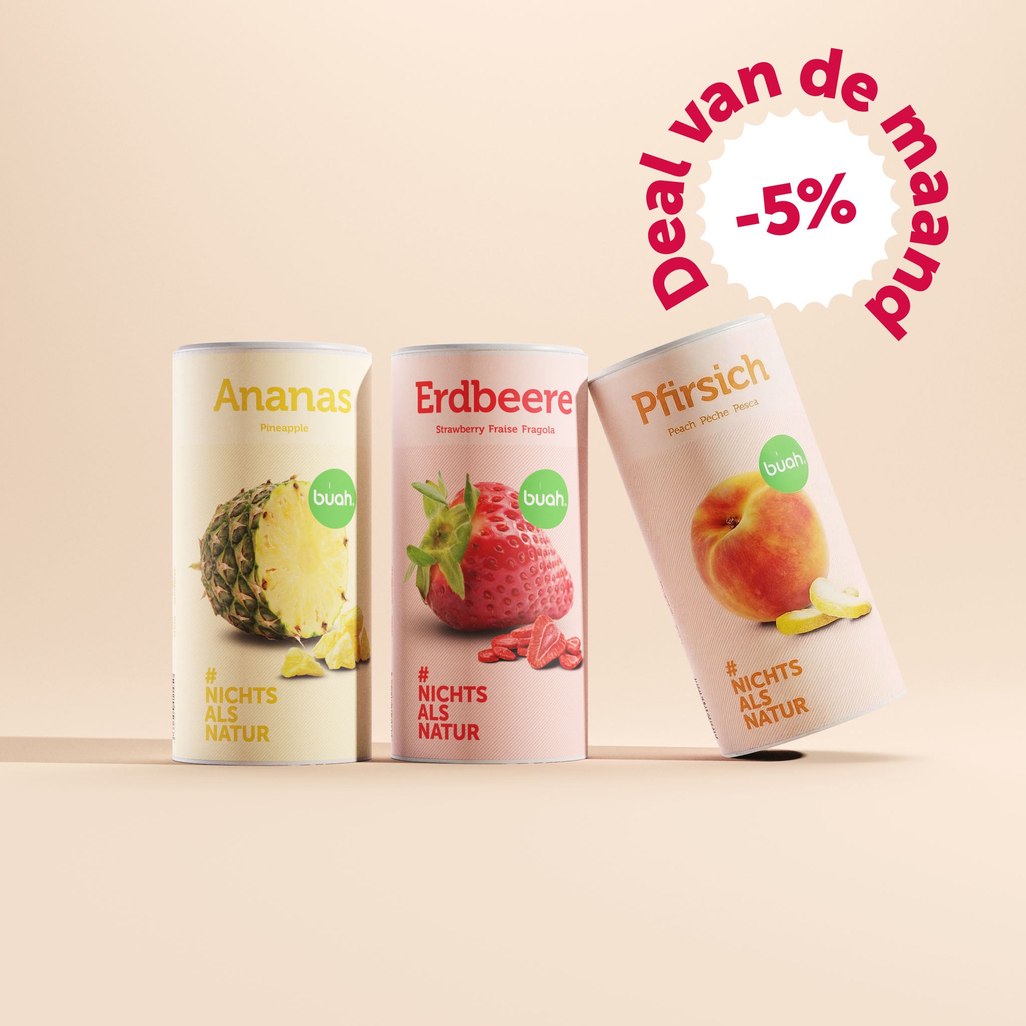 Drie grote bussen buah gevriesdroogd fruit in de smaken ananas, aardbei en perzik staan tegen een beige achtergrond, waarbij de perzik bus iets naar rechts gekanteld is. Rechtsboven toont een bubbel "Deal van de maand -5%".