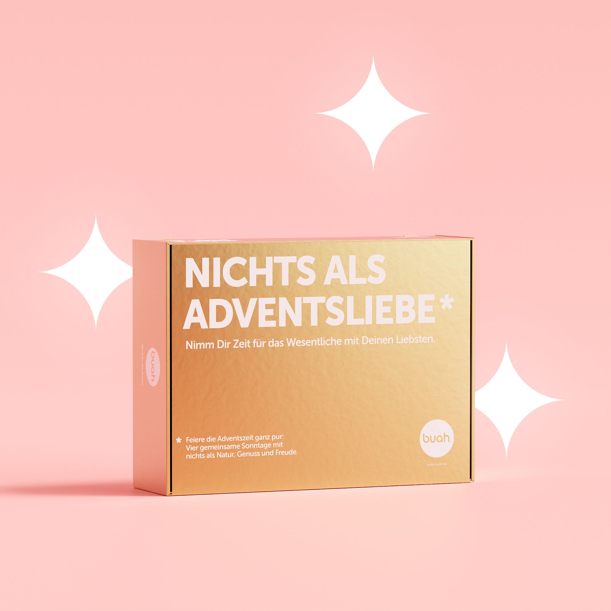 buah Adventskalender in goldener, rechteckiger Packung mit der Aufschrift Nichts als Adventsliebe vor rosa Hintergrund 