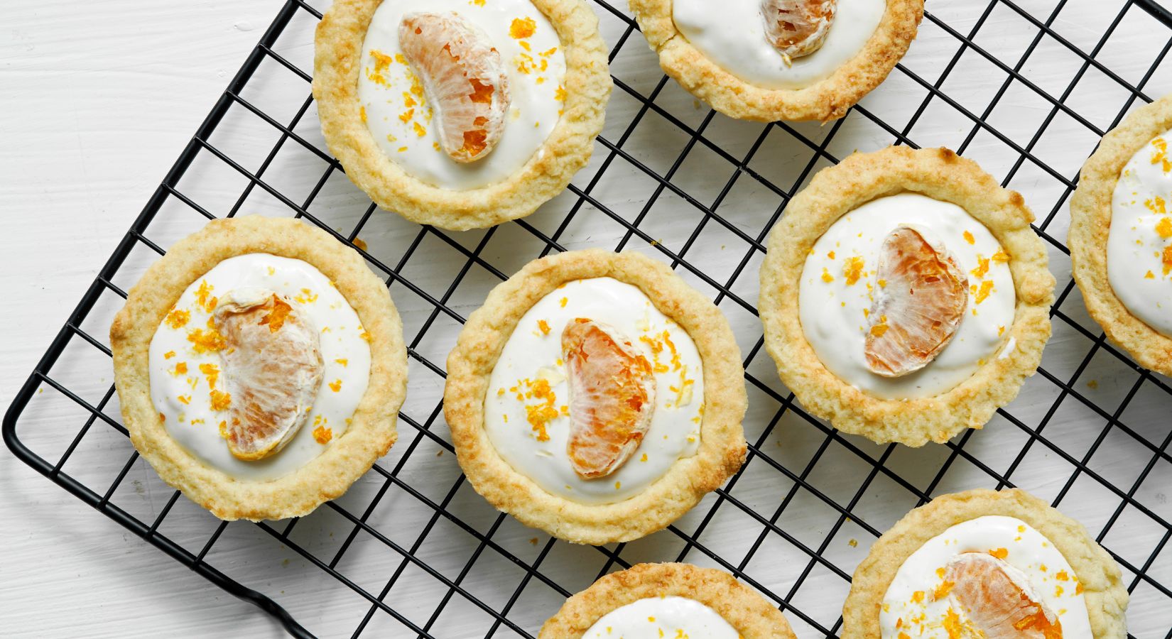 Mini Mandarinen Kuchen mit weißer Glasur und buah gefriergetrockneter Mandarine als Dekor